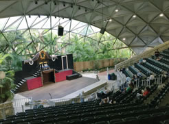 Pinecrest Gardens aphimpheater, with white paneled ceiling to stage and glass from there, a two-story set, palm trees in background.