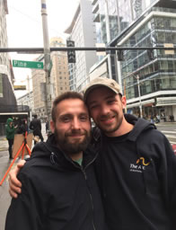 Photo of Josh and Ian, arms around each other, on a downtown street