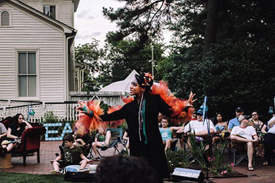 Production photo of Ariel with the audience and Poe House in the background.