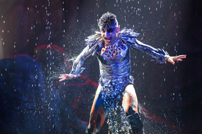 Arial dancing with water raining down around him.